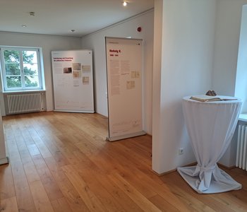 Ein Teil der Ausstellung mit Stehtisch und Schautafeln.